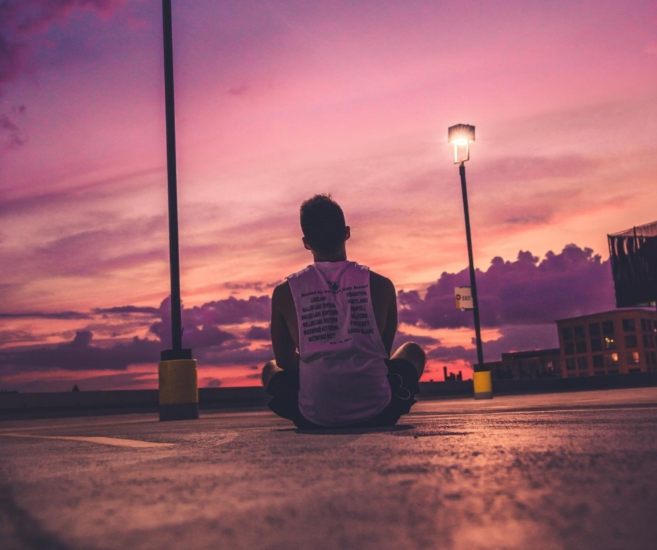 Man Sitting On Ground At Sunset Man Sitting On Ground At Sunset