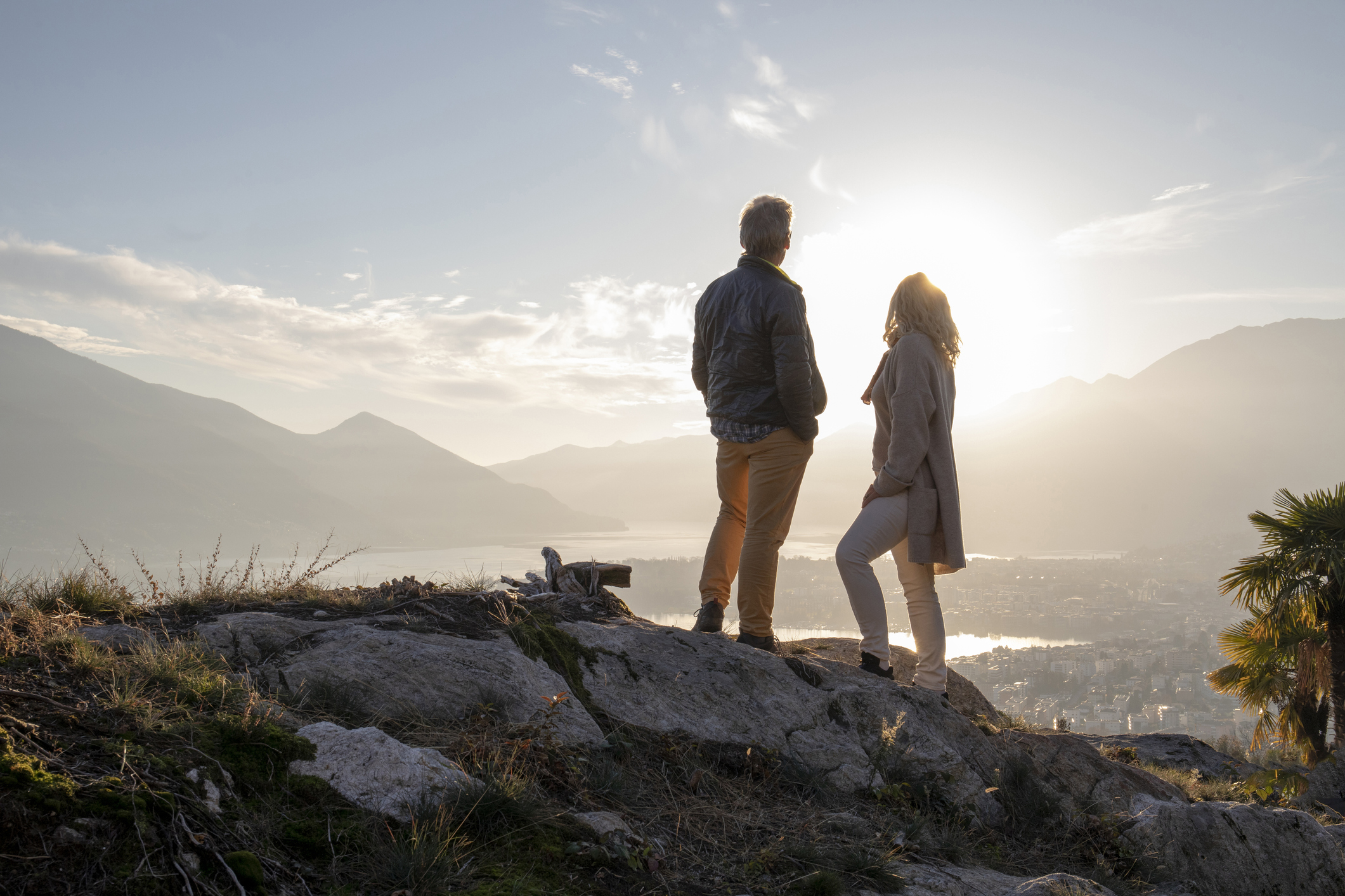 Mature couple hike along sunny mountain ridge, sunset Wealth Management Services